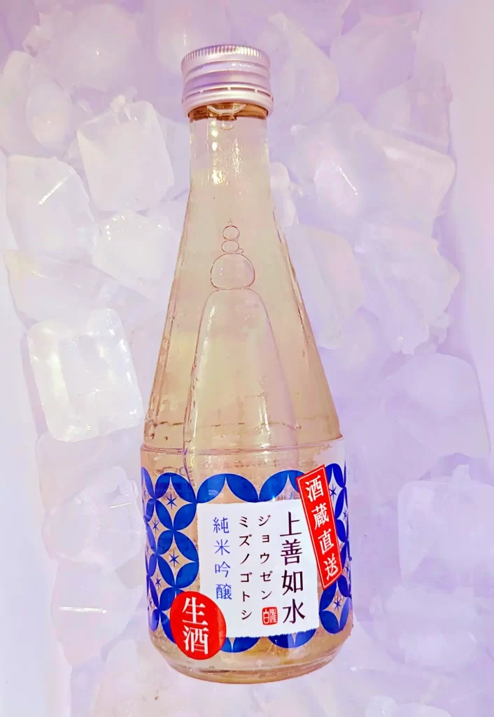 氷で冷やしたクーラーボックス内に置かれた「上善如水 純米吟醸 生酒」。青と白を基調としたラベルデザインが特徴で、「酒蔵直送」と「生酒」のシールが貼られている。ボトルには結露した水滴が見られ、夏場の晩酌や冷酒に適した飲み頃の状態を表現した商品写真。