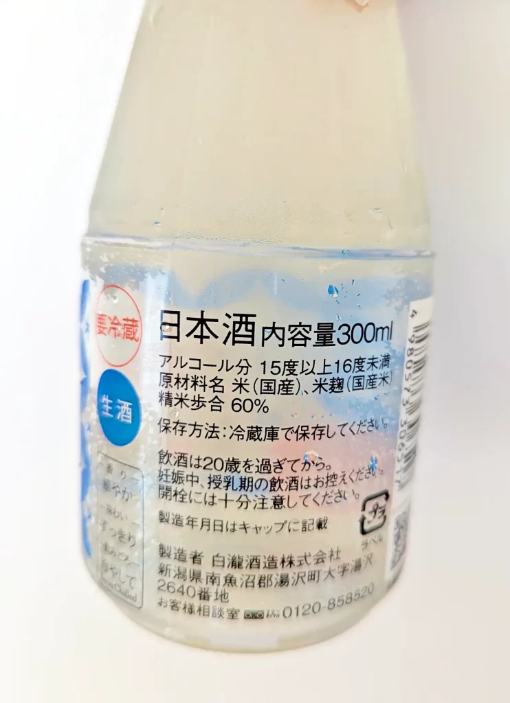 白瀧酒造が製造する生酒の裏ラベル。内容量300ml、アルコール分15～16度未満、精米歩合60％、原材料は国産米と米麹と記載されている。冷蔵保存された白く濁る日本酒の小瓶で、ラベルには保存方法や製造者情報も掲載されている。