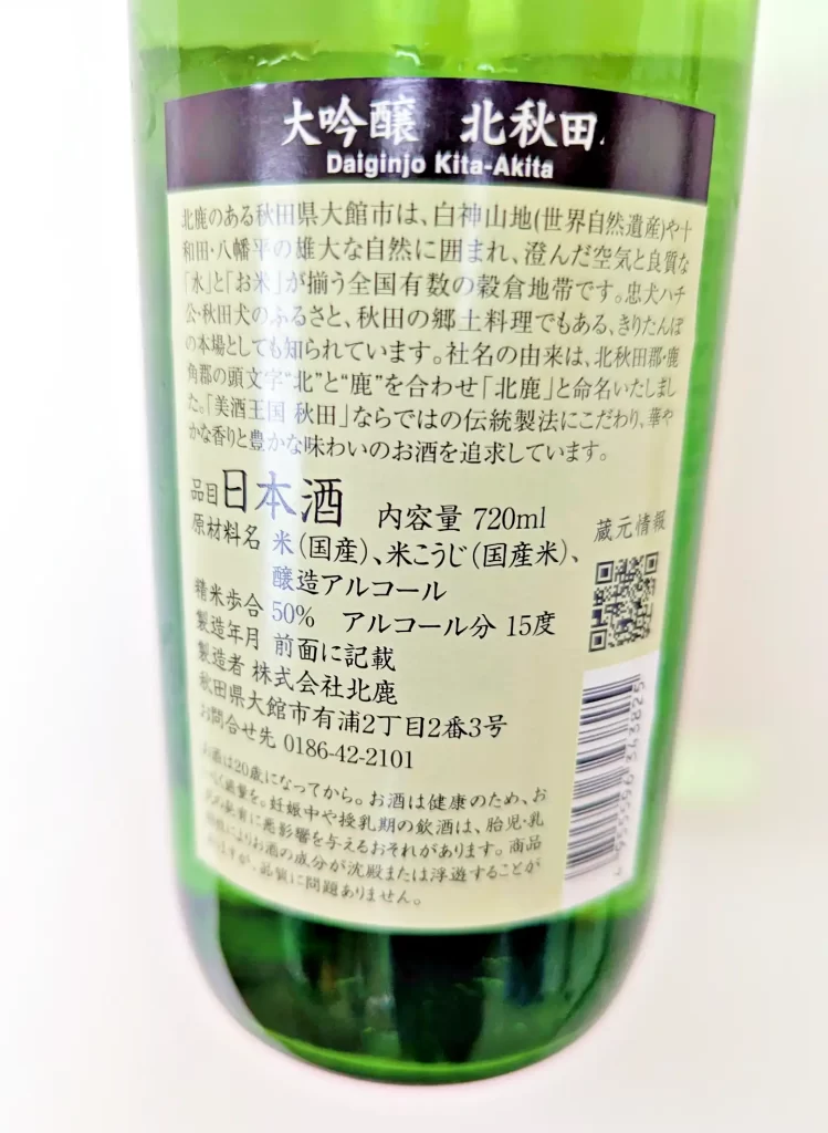 「大吟醸 北秋田」の裏ラベル。秋田県大館市の酒蔵・株式会社北鹿が製造する日本酒で、原材料は国産米・米こうじ・醸造アルコール。内容量720ml、精米歩合50%、アルコール分15度と記載されている。商品説明、製造者情報、QRコード、バーコードが確認できる商品情報ラベルの写真。