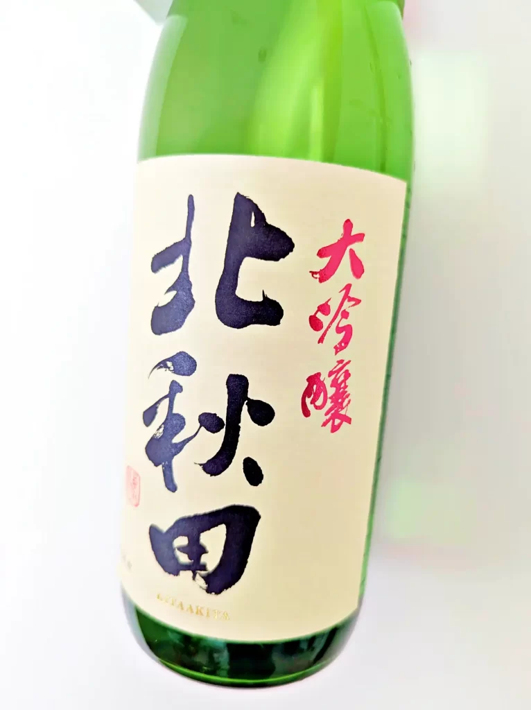 秋田県の日本酒「大吟醸 北秋田」のボトル写真。緑色の瓶に白いラベルが貼られ、力強い筆文字で「北秋田」、赤字で「大吟醸」と表示されている。白背景で撮影されており、商品の外観やラベルデザインを確認しやすい日本酒の商品画像。